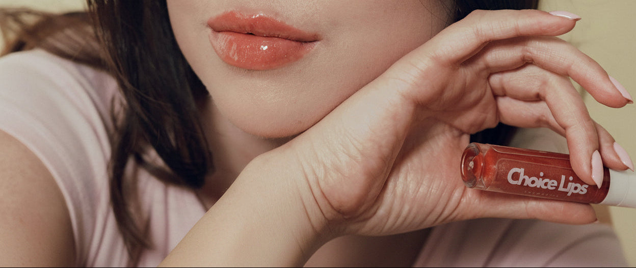 Person holding a lip gloss with 'Choice Lips' branding
